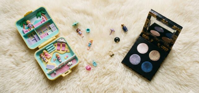 Polly Pocket Energy: The Rise of Micro-Palettes A flat lay on a fuzzy rug. An open vintage Polly Pocket on the left, an open Pat McGrath quad on the right.